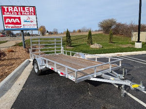 Silver Ox Mighty Lite 6x12 Aluminum Utility Trailer parked on the lot with visible ramp gate, tie-downs, and aluminum construction.