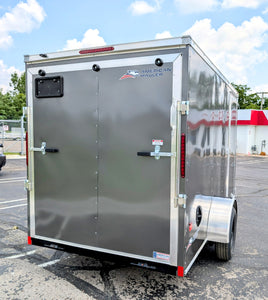 Silver enclosed trailer with American Hauler logo on a parking lot