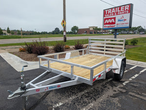 Silver Ox trailer parked on a paved area with a 'Trailer Sales & Parts' sign in the background.
